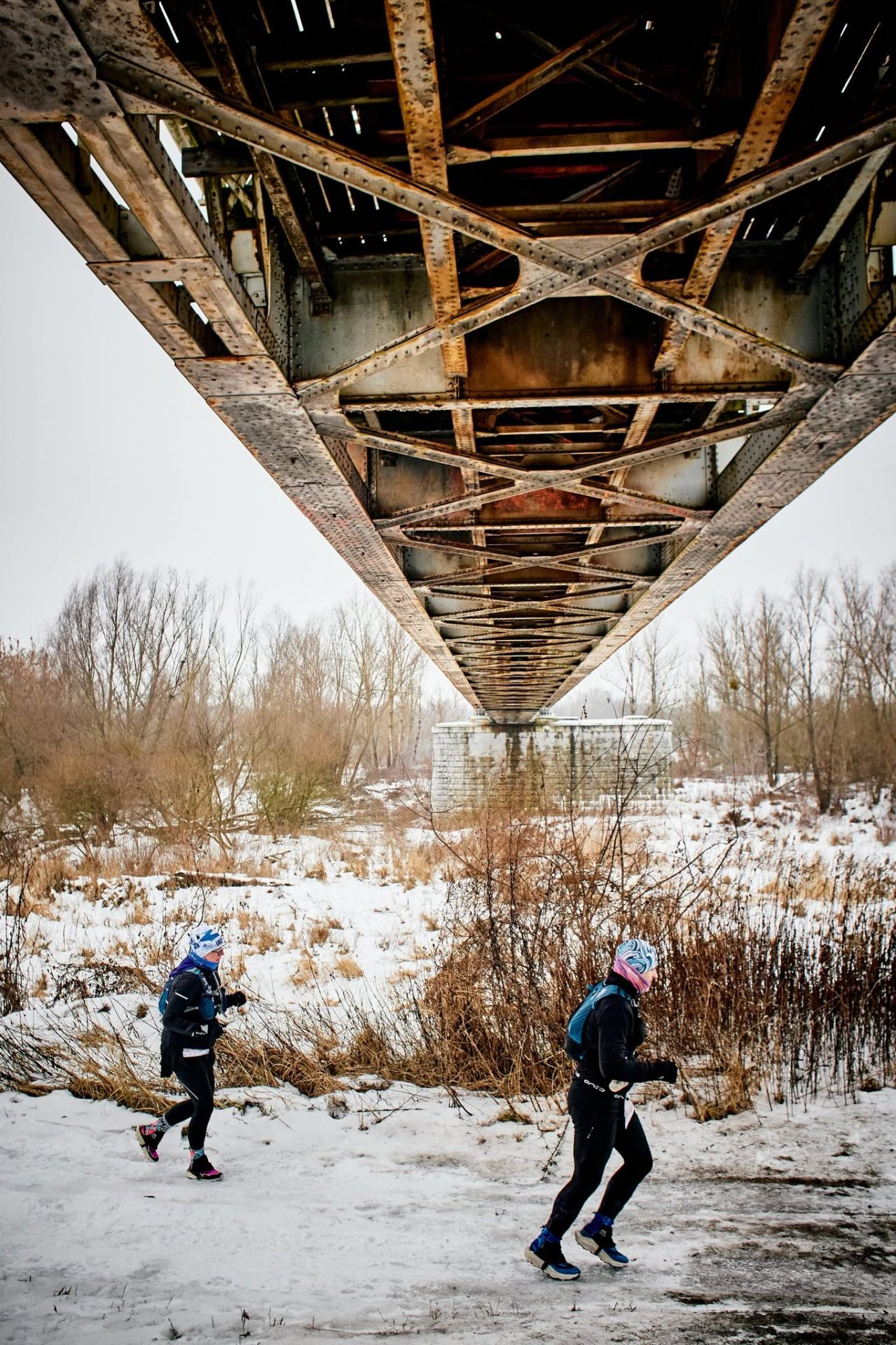 Biegacze URUŚ pod stalową konstrukcją starego mostu kolejowego nad Świdrem